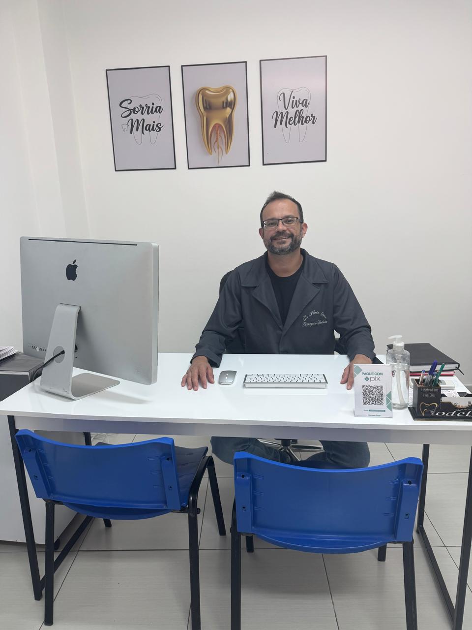 Dr. Plínio em sua mesa no consultório odontológico em Goiás